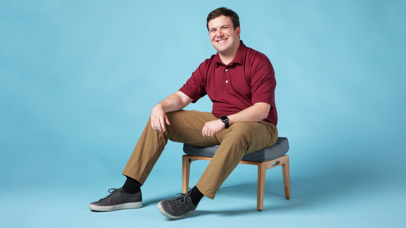A man sitting in a brown pair of ABC Pants.