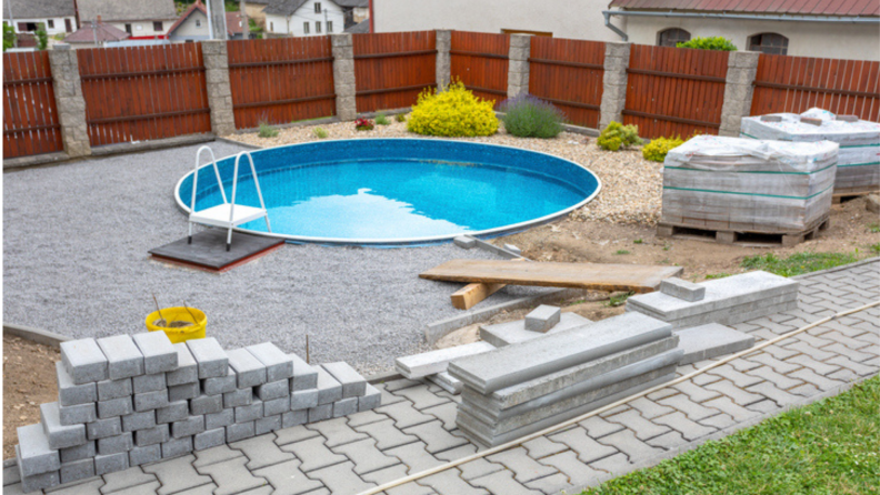 An in-ground pool under construction in a residential backyard.