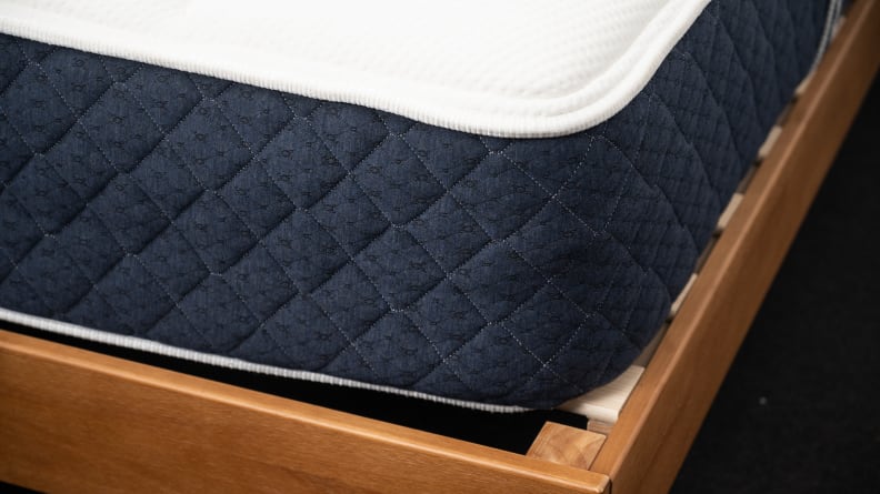 the corner of the Brooklyn Bedding Signature Hybrid on a bed frame