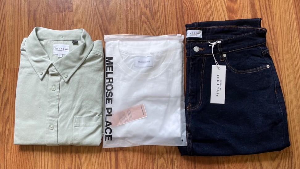 a folded overshirt, a packaged white T-shirt, and folded blue jeans from Menlo Club