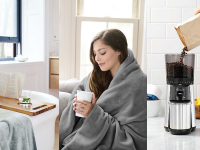 A woman snuggled under a blanket drinking a cup of coffee