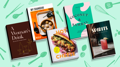 Five cookbooks on a mint colored, patterned background