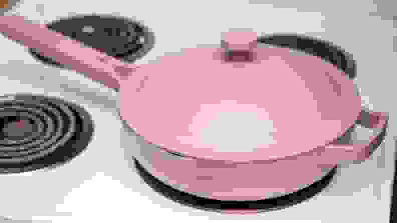 A lavender colored Always pan is on a white stove.