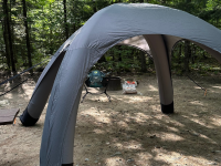 The SOLI tent set up within some woods.