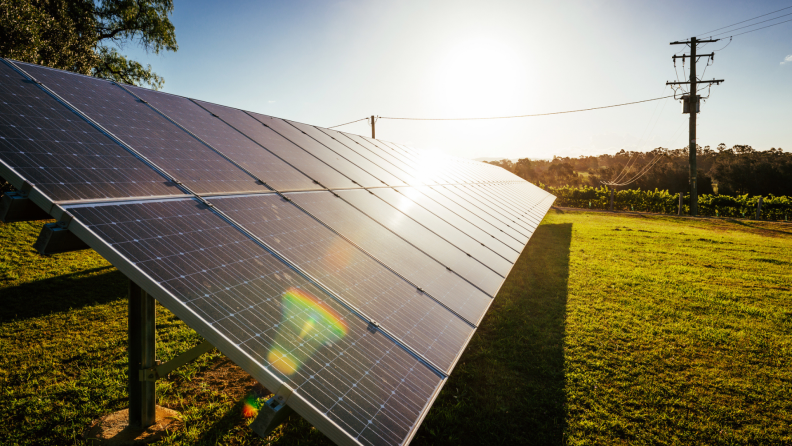 Large solar panel board in yard on sunny day.