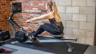 A person exercises using a rowing machine.