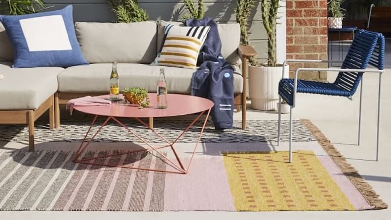 A colorful patterned rug on a patio.
