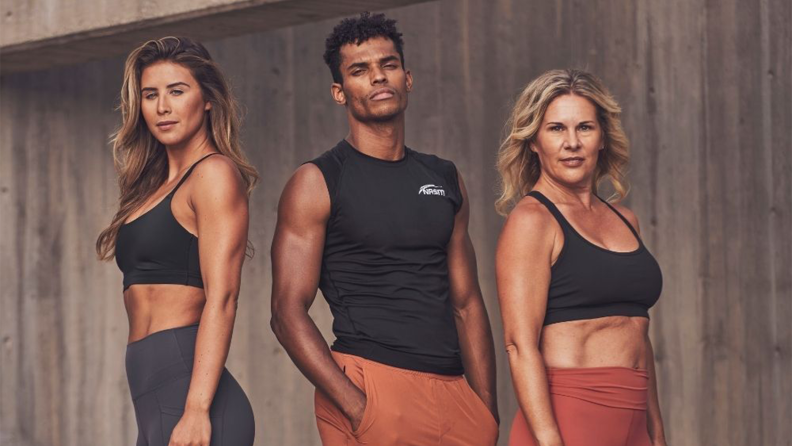 Three certified personal trainers posing against a wall.