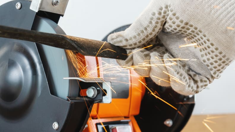 Person sharpening blade with electric sharpener.