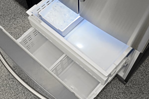 The Samsung RF260BEAESR's pull-out freezer is spacious, and contains an ice maker with removable bucket.