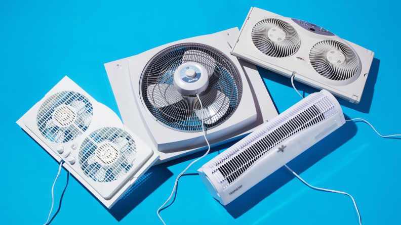 Four window fans, including our top picks—the best overall, Vornado Transom AE, the best circulator,  Window Air Circulator, the Air King 9155, and the best value, Bionaire BW2300-N—plus the Amazon Basics window fan, all floating on a blue background.