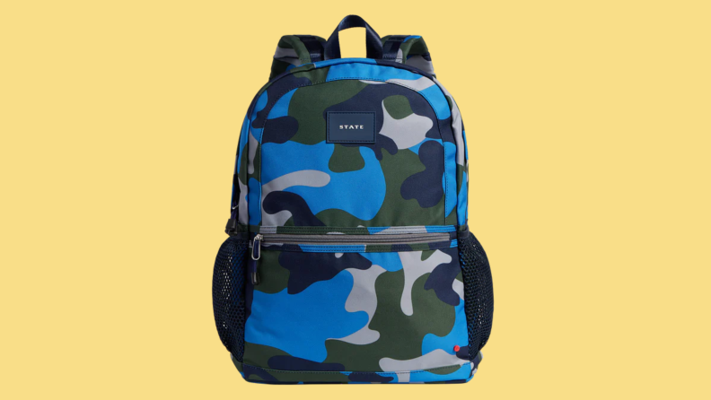 A State brand, blue camo backpack on a yellow background.