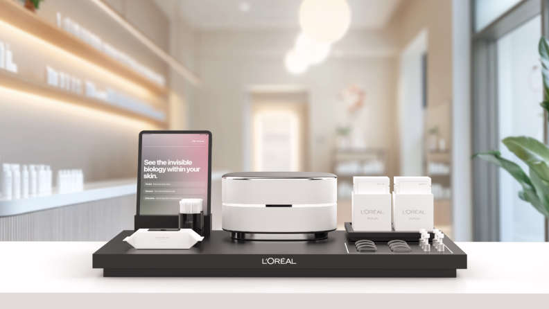 A sleek L'Oréal skincare diagnostic system displayed on a counter, featuring a futuristic device, accompanying products, and a tablet with an interactive interface, set in a modern, well-lit environment.