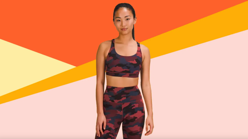 Model wearing red and black camouflage activewear set.