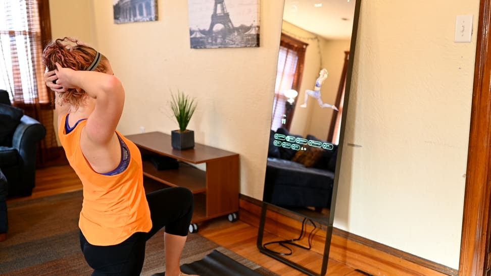 A woman taking a yoga class with the Mirror.