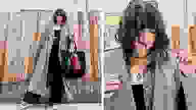 A woman wearing a plaid coat, wide-leg trousers, a plaid shirt, red Converse sneakers, a black tote bag and jewelry.