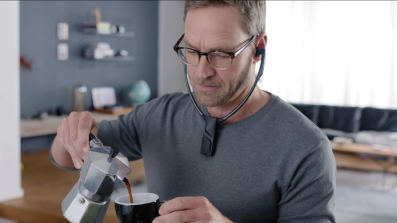 Man pouring coffee wearing headphones