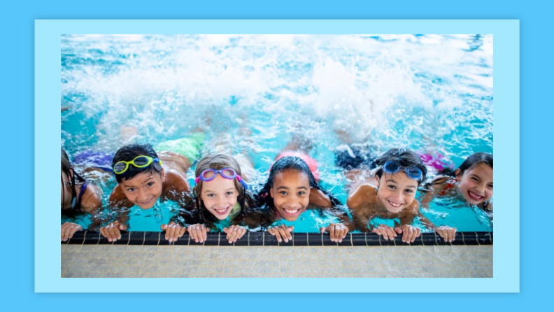 A group of elementary school children are at the pool. They are smiling and posing for the camera.