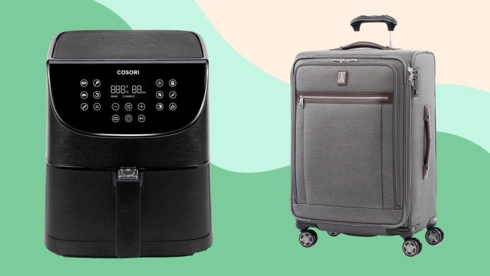 On left, black Cosori air fryer in front of green background. On right, small gray Travelpro rolling suitcase.