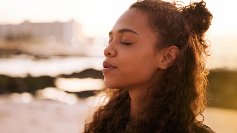 a person with their eyes closed standing outside