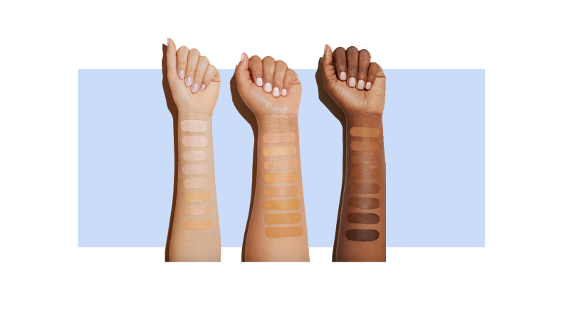 Close up of three arms of different skin colors in front of a background.
