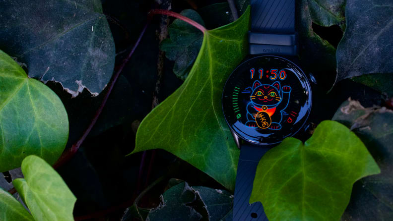 The GTR 3, with a neon animated cat watch face, resting in a bush.