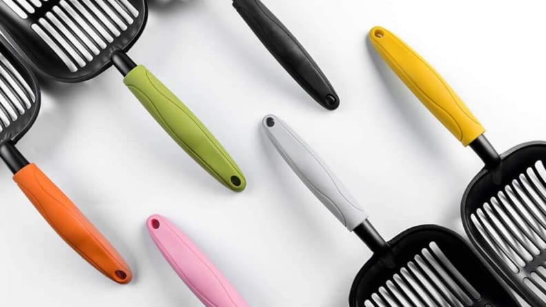 An image of cat scoopers with different colored handles.