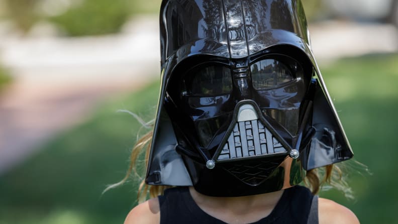 A child wears a shipDisney Darth Vader mask.