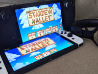 Two handheld gaming consoles next to a wireless headset