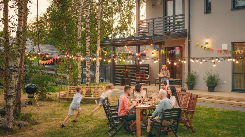 A backyard full of people with string lights hanging above.