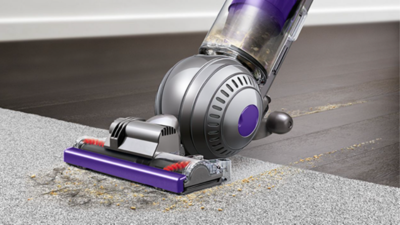 An image of a Dyson Roller Ball Animal 2 vacuuming up dirt on a carpet.