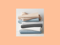A stack of blue, white, black, and beige pillowcases set on an orange background