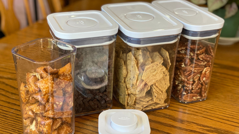 Clear food storage containers with food inside on top of table top.