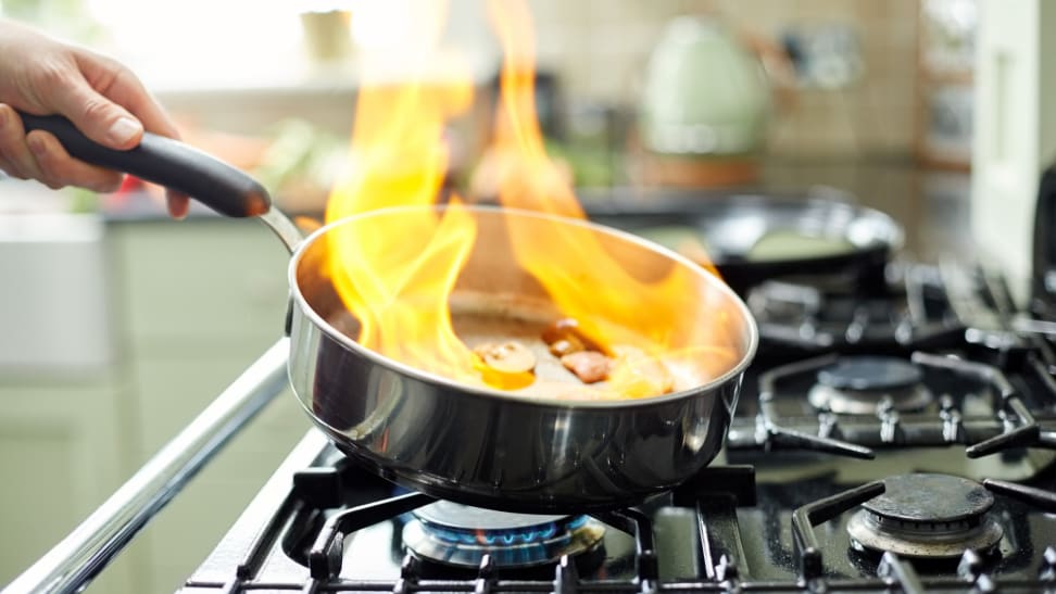 锅放在炉子上，火从里面冒出来。