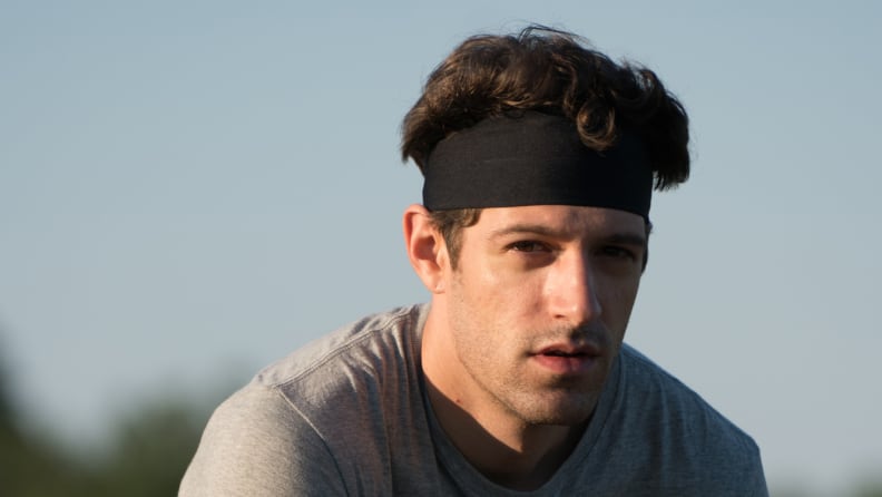 White man with brown hair wearing black headband