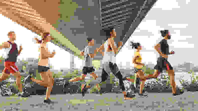 a group of men and women running together under a bridge