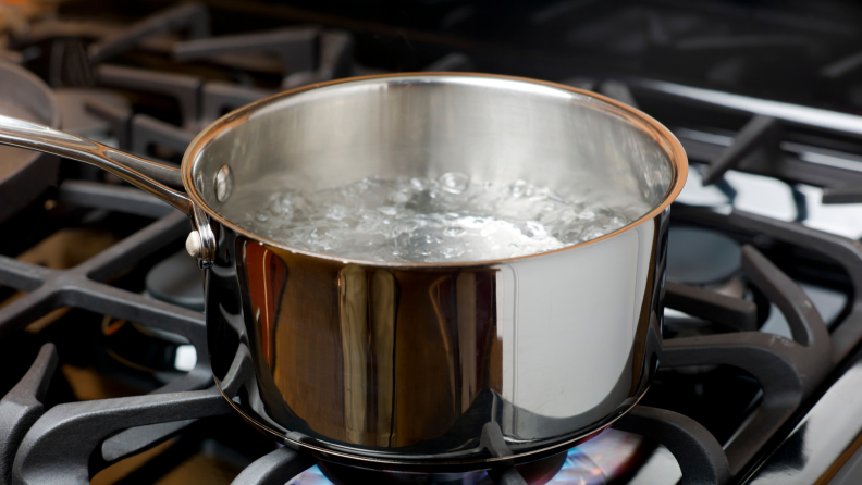 Stainless steel pot with boiling water on a stove