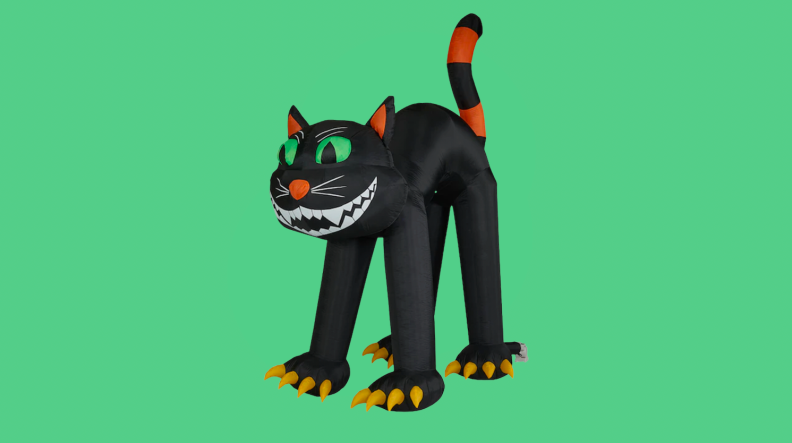 An inflatable Halloween decor black cat appears on a green field.