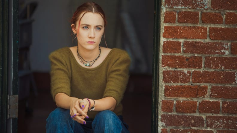 Saoirse Ronan sits alone outdoors in the 2017 film Lady Bird.