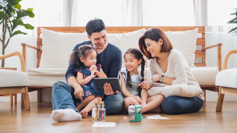 Family huddled around a tablet in the living room