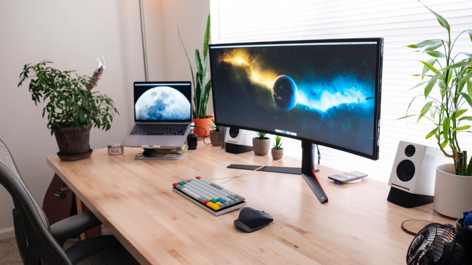 A Macbook Pro and a gaming keyboard connected to a larger monitor.