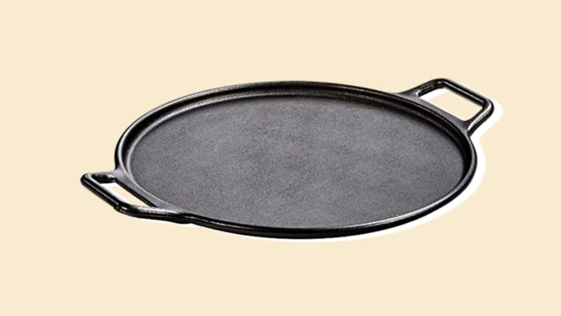 A pizza stone with handles on a beige background.