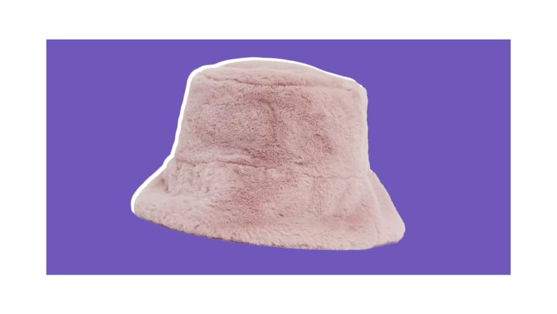 A pink fuzzy bucket hat against a purple background.
