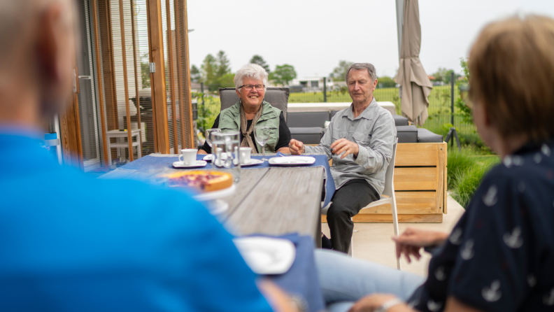 Two senior couples enjoy an afternoon meal while social distancing.