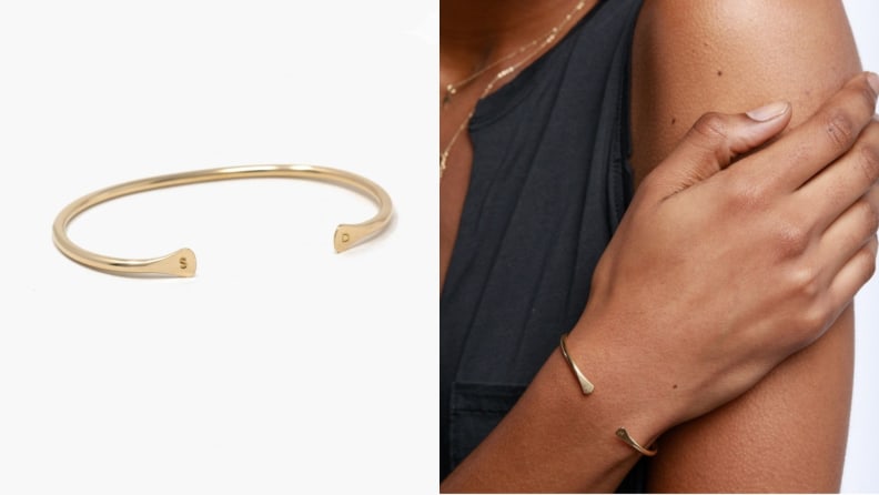A gold cuff with initials stamped on it.
