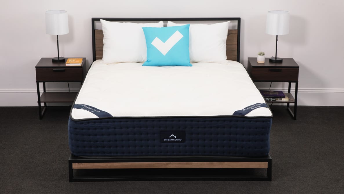The DreamCloud hybrid mattress in a bedroom between two bedside tables.