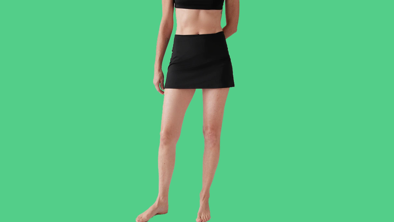 white woman wearing black skirt on green background