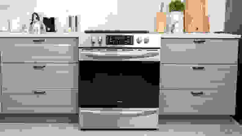 The Frigidaire FGEH3047VF electric range installed between two grey kitchen cabinets.
