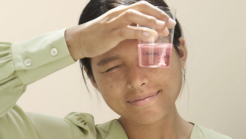 A lady looking at mouthwash.