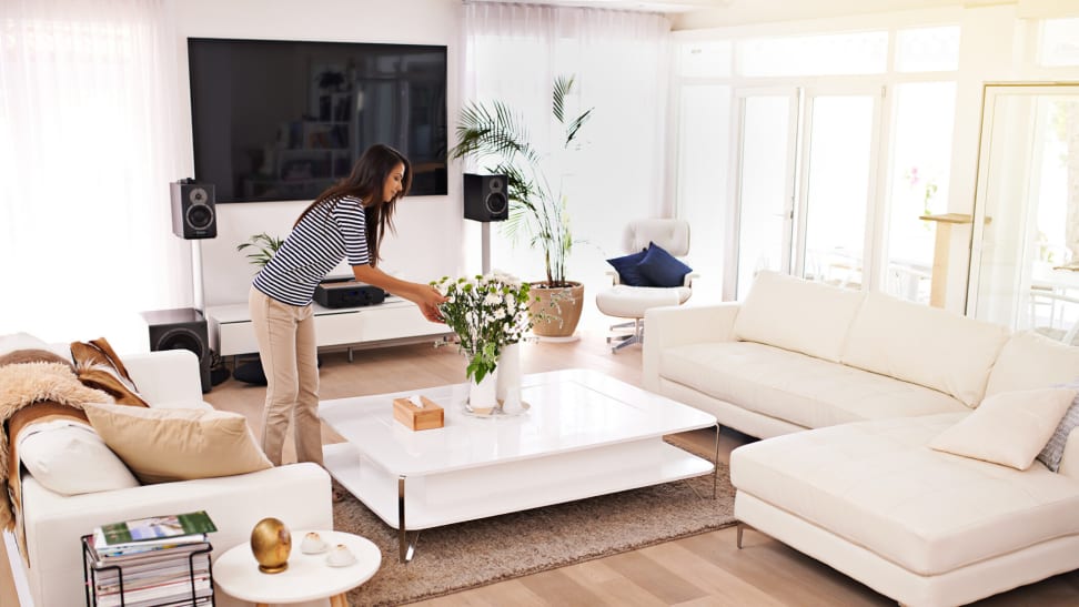 Woman tending to a plant in a bright living room